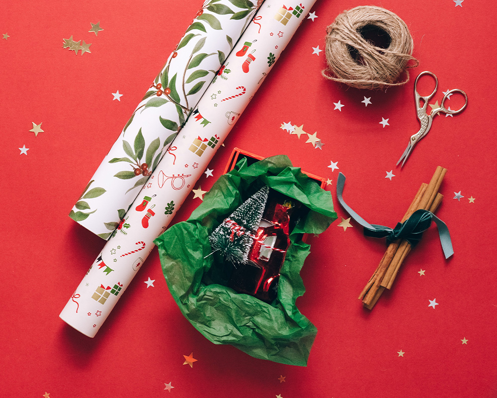 Materiały do pakowania prezentów: papier pakunkowy, sznurek, nożyczki i akcesoria.