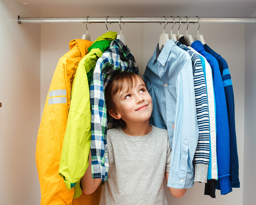 Chłopiec w szafie z ubraniami
