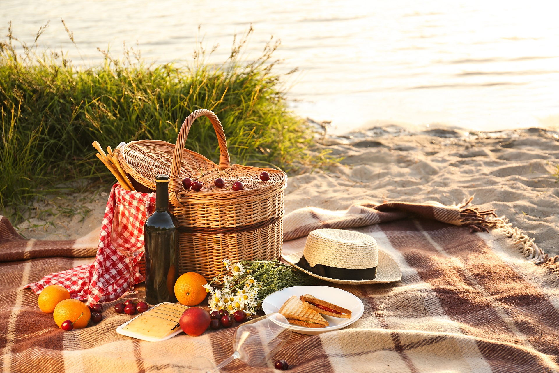 Kosz piknikowy na romantyczną kolację na plaży koło rzeki 