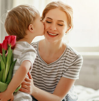 Mały chłopiec daje mamie bukiet tulipanów na dzień matki